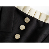 버튼 포인트와 어깨끈이 돋보이는 세련된 블랙 드레스