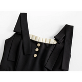 버튼 포인트와 어깨끈이 돋보이는 세련된 블랙 드레스